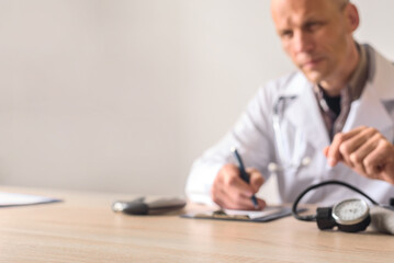 Confident doctor in white coat consulting patient in office clinic interior. Healthcare professional taking notes during patient appointment in office