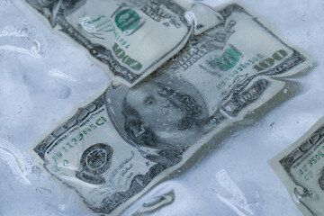 Multiple One Hundred Dollar Bills in Ice