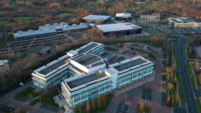 Aerial view of modern buildings with surrounding car parks and roads, creating a contrasting blend of urban infrastructure and natural landscapes, Solihull, England, United Kingdom.