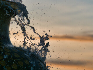 The fountain from the earthenware pot reflects the evening light.