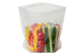 Reusable silicone food storage bag filled with fresh-cut vegetables isolated with transparent background