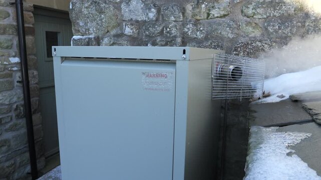 4K: Outside Oil Boiler in Winter emitting Plumes of Steam. Vortex boiler exterior in Snow and icy cold Weather. Stock Video Clip Footage.
