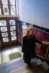 A young girl in a coat climbs an ancient staircase