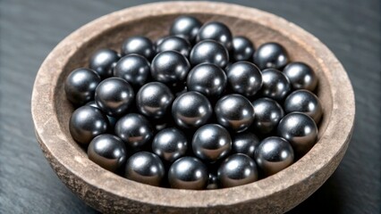 Dark round objects placed in a wooden bowl on a flat surface in a simple setting