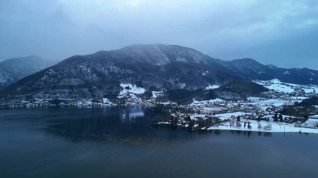 Aerial drone hover over snowy mountain landscape near Traunsee lake, Austria