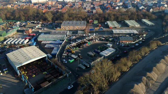 Aerial view of industrial buildings, storage yards, parked vehicles, and stockpiles, creating a textured tableau of commerce, Rugby, England, United Kingdom.
