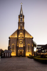 Illuminated stone church at sunset in Gramado Brazil with European architecture and peaceful evening atmosphere