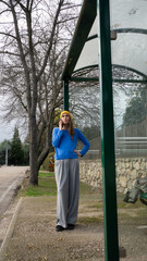 Woman talking on phone waiting at bus stop