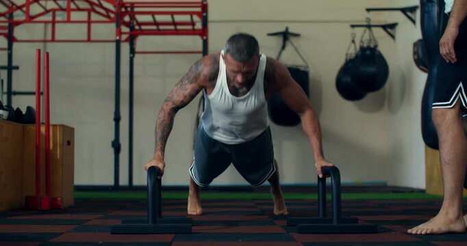 Close-up of MMA athlete doing push-ups during training.