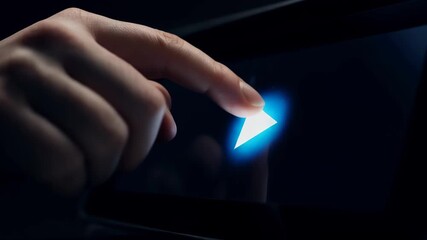 User interacts with a screen by touching a play button in dark surroundings to start a media session