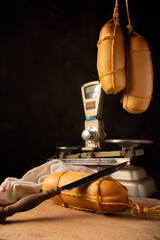 Provolone cheese, wonderful smoked provolone cheese on rustic wood and accessories, abstract background, selective focus.