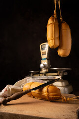 Provolone cheese, wonderful smoked provolone cheese on rustic wood and accessories, abstract background, selective focus.