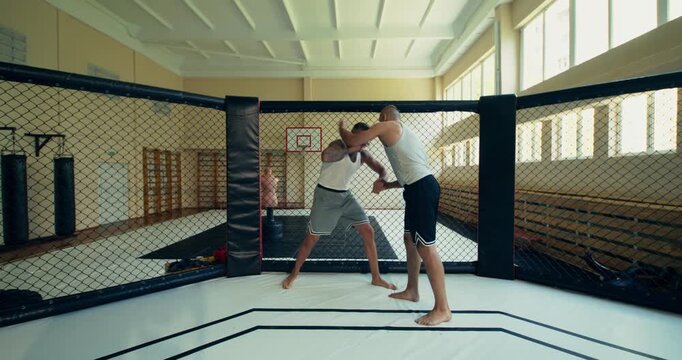 A mixed martial artist applies a chokehold against his opponent during a fight and then celebrates his victory.