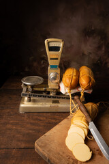 Provolone cheese, wonderful smoked provolone cheese on rustic wood and accessories, abstract background, selective focus.