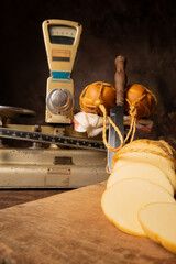 Provolone cheese, wonderful smoked provolone cheese on rustic wood and accessories, abstract background, selective focus.
