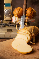 Provolone cheese, wonderful smoked provolone cheese on rustic wood and accessories, abstract background, selective focus.