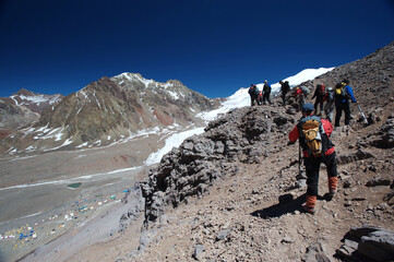 The movement of climbers in rows in extreme conditions on snowy, steep mountains