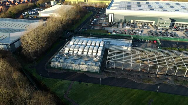Birmingham, United Kingdom - 31 December 2025: Aerial view of the ATOS long bridge data centre, surrounded by industrial buildings and parked vehicles.