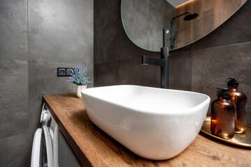 Fototapeta premium A bathroom with a sink, mirror, and a washer