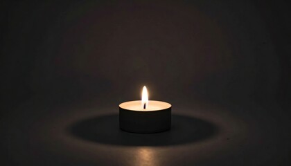 Lit candle on black background with light coming from the top candle.