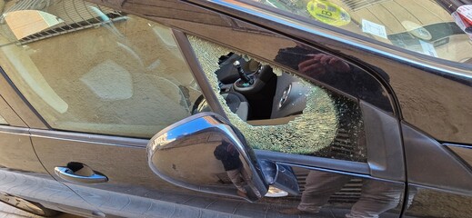 Coche con ventanilla rota para robar , concepto inseguridad ciudadana y aumento de la delincuencia.