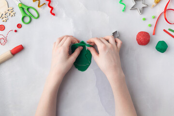Play dough and Christmas decorations. Little child hands creating Christmas crafts. Holiday Art Activity for Kids. Sensory play for toddlers.