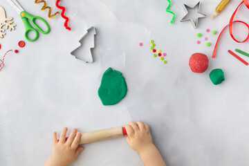 Play dough and Christmas decorations. Little child hands creating Christmas crafts. Holiday Art Activity for Kids. Sensory play for toddlers.