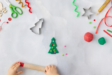 Play dough and Christmas decorations. Little child hands creating Christmas crafts. Holiday Art Activity for Kids. Sensory play for toddlers.