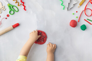 Play dough and Christmas decorations. Little child hands creating Christmas crafts. Holiday Art Activity for Kids. Sensory play for toddlers.