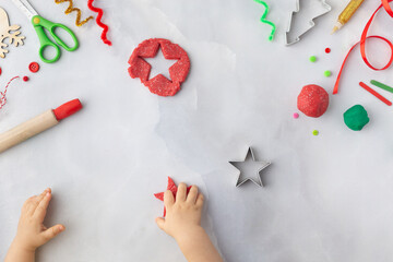 Play dough and Christmas decorations. Little child hands creating Christmas crafts. Holiday Art Activity for Kids. Sensory play for toddlers.