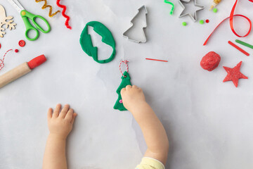 Play dough and Christmas decorations. Little child hands creating Christmas crafts. Holiday Art Activity for Kids. Sensory play for toddlers.