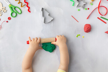 Play dough and Christmas decorations. Little child hands creating Christmas crafts. Holiday Art Activity for Kids. Sensory play for toddlers.