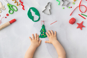 Play dough and Christmas decorations. Little child hands creating Christmas crafts. Holiday Art Activity for Kids. Sensory play for toddlers.