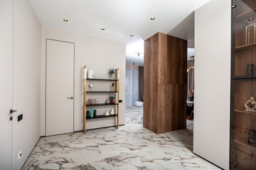 A white room with a brown door and a shelf with a vase on it