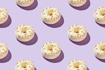 Overhead view of various donuts with confetti arranged on colored background