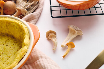 Quiche with chanterelle mushrooms, oyster mushrooms, button mushrooms, and cheese in two serving dishes