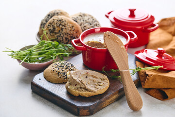 Gourmet Liver Pate Appetizer with Sesame Seed Bagels and and Fresh Pea Shoots on Rustic Wooden Board