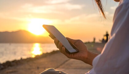 Woman using tablet at serene sunset.