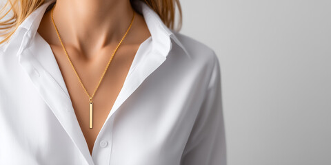 Woman wearing minimalist gold vertical bar pendant necklace over elegant white shirt, highlighting modern luxury and timeless style.