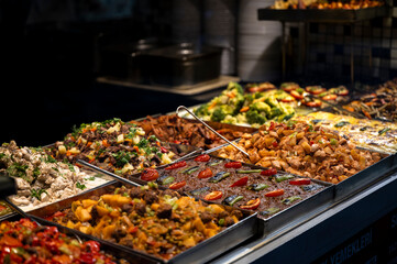 Assortment of traditional Turkish dishes in metal trays at a local self-service restaurant