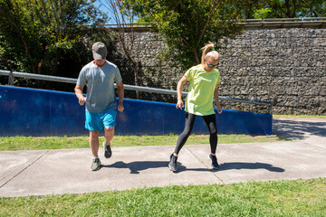 Mature couple in sportswear doing coordination and agility exercises outdoors in a park