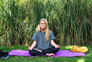 Mid-adult woman in sportswear focusing on breathing exercises outdoors