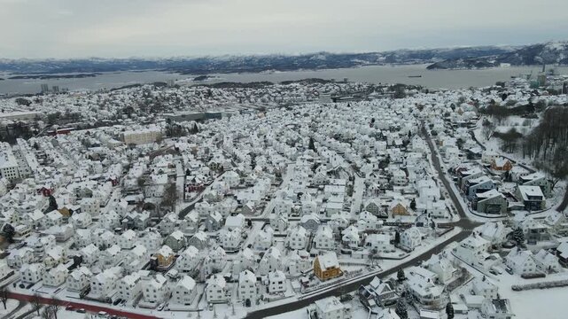 Aerial drone footage showing an urban neighborhood in Stavanger, Norway covered in snow during winter. The scene includes residential buildings, streets, and surrounding infrastructure, documenting ty
