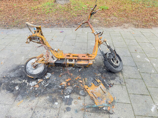 Burned Electric Scooter Wreck on Urban Sidewalk