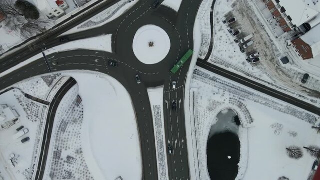 Aerial drone footage showing vehicle traffic moving through an urban area in Stavanger, Norway during winter. The scene captures roads, surrounding buildings, and typical city infrastructure under col