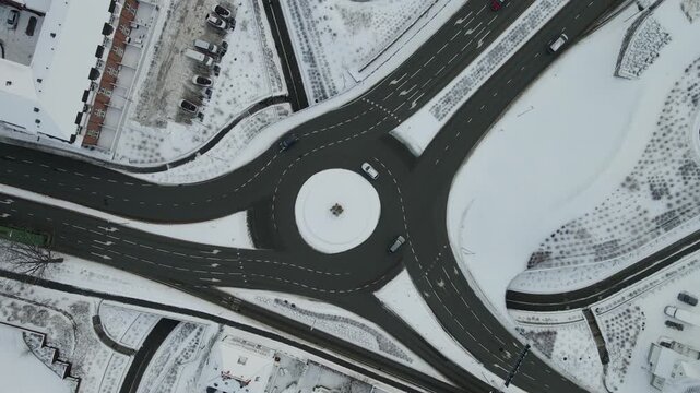Aerial drone footage showing vehicle traffic moving through an urban area in Stavanger, Norway during winter. The scene captures roads, surrounding buildings, and typical city infrastructure under col