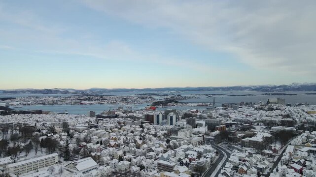 Aerial drone footage showing an urban neighborhood in Stavanger, Norway covered in snow during winter. The scene includes residential buildings, streets, and surrounding infrastructure, documenting ty