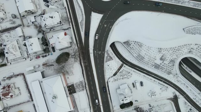 Aerial drone footage showing vehicle traffic moving through an urban area in Stavanger, Norway during winter. The scene captures roads, surrounding buildings, and typical city infrastructure under col