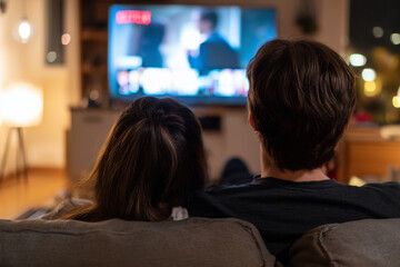 Couple watching a streaming movie on a couch at home, streaming provider, streaming services 