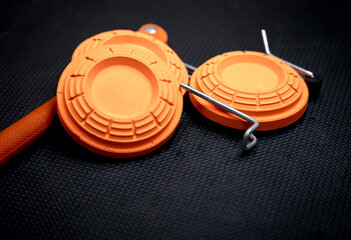 clay orange target setup on a hand thrower, used for sporting clays, skeet and trap	